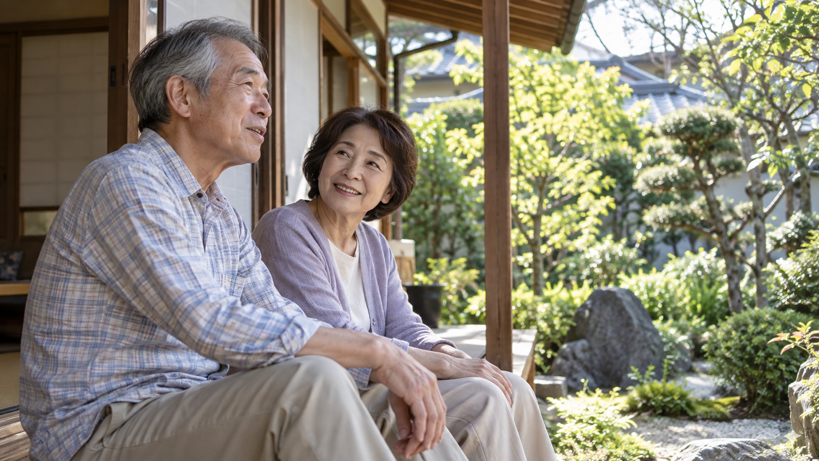 庭を眺めながら縁側で会話するシニア夫婦